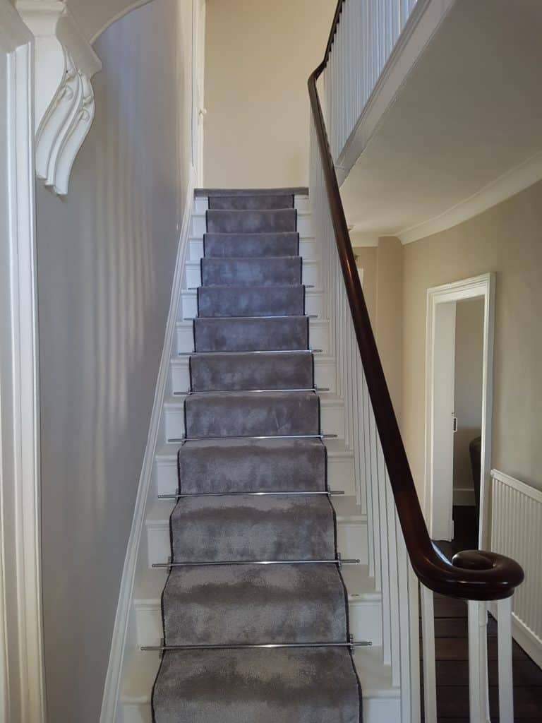 wooden staircase with grey carpet